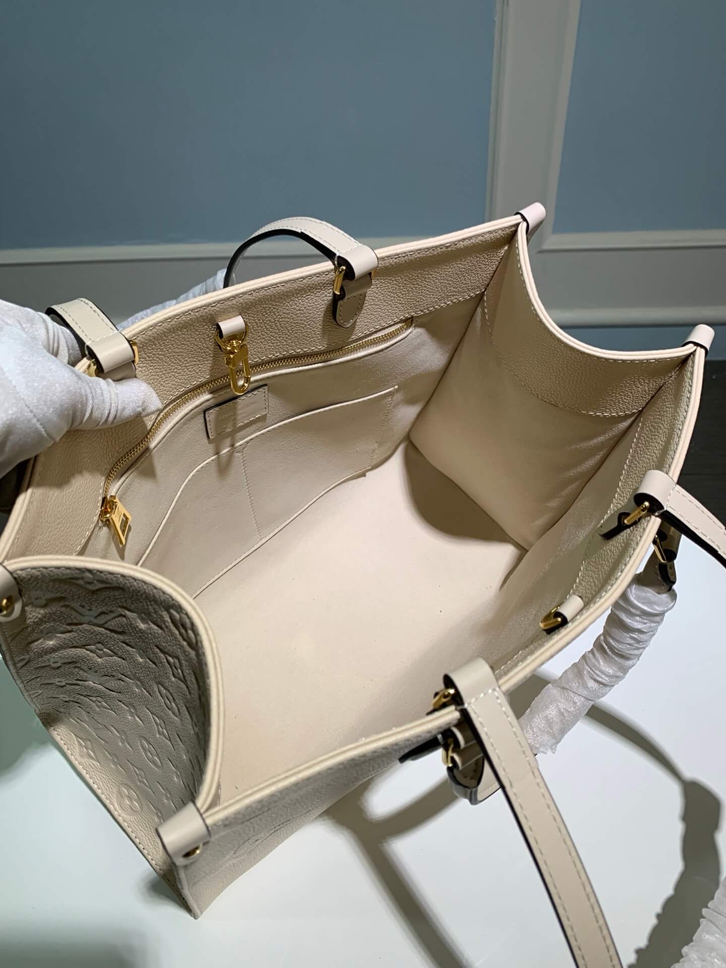 M45595 OnTheGo MM Monogram Empreinte leather white 35cm